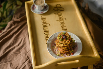 tasty breakfast in bed from eastern pancakes and Masala tea, served on the wood folding breakfast table