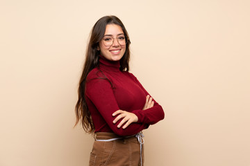 Teenager girl with glasses with arms crossed and looking forward
