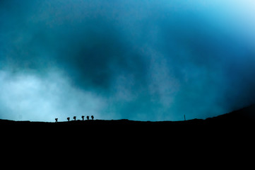 Group of hikers on a moutain ridge before incoming storm