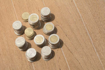 Many Thai coins are stacked on the wooden table, Many of Thai baht coins background with copy space
