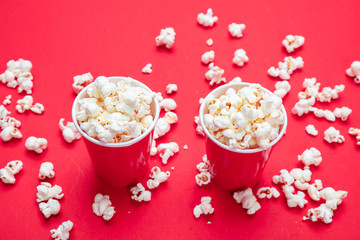 Fototapeta na wymiar Pop corn in red paper cups on red color background