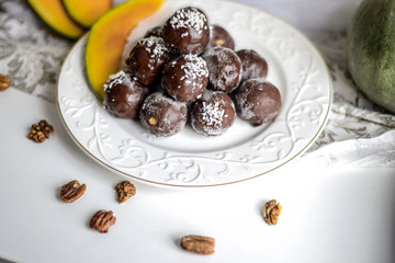 tasty homemade pumpkin candy balls in dark chocolate topping of coconut crumbs