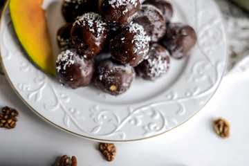 tasty homemade pumpkin candy balls in dark chocolate topping of coconut crumbs