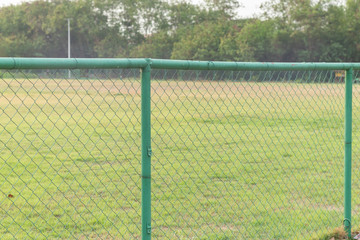 green metal fence at grass football field