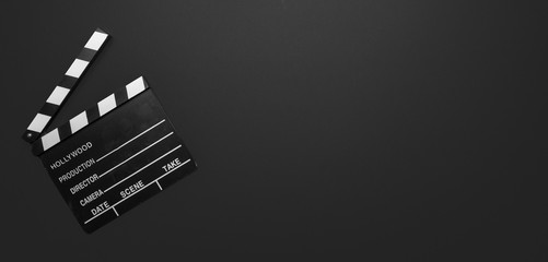 Movie clapperboard on black color background, banner, top view