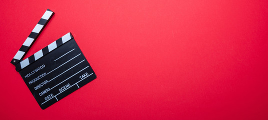 Fototapeta na wymiar Movie clapperboard on red color background, banner, top view