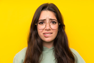 Teenager girl with sweatshirt having doubts and with confuse face expression