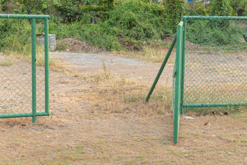 Fototapeta na wymiar green metal fence at grass football field