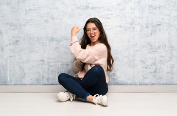 Teenager student girl studying in a table doing strong gesture