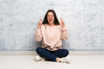 Teenager student girl studying in a table with fingers crossing