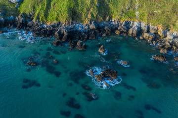 Sea waves breaking in the reefs and coast of Sonabia, Spain, Cantabrian sea - drone aerial view