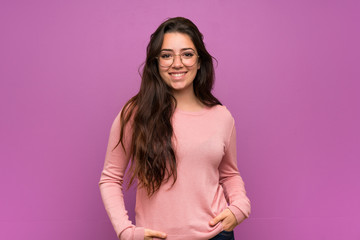 Teenager girl over purple wall laughing