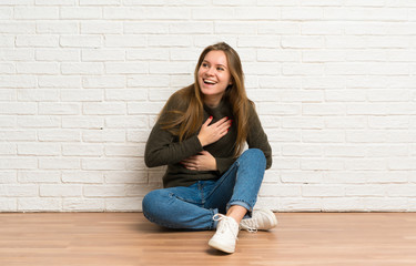 Fototapeta na wymiar Young woman sitting on the floor smiling a lot