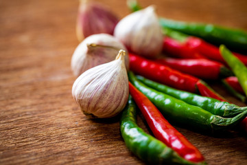 Garlic tone and Red green chili pepper on wooden background
