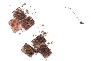 Broken make up and cosmetic products. Smashed eye shadow palette in neutral colors isolated on white background.