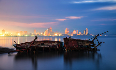 Shipwreck in Kratinglay beach Chonburi with beautiful sunset and twilight sky