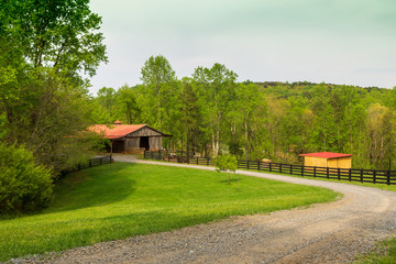 A red-roofed barn on the farm in the spring.
