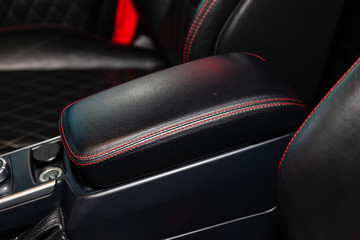 A view of a part of the interior of the car dashboard and seats from leather of black color,...