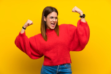 Young woman over isolated yellow wall celebrating a victory