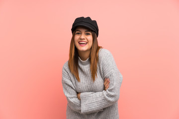 Fashion woman with hat over pink wall laughing