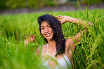 Naklejka na ściany i meble young happy and beautiful latin woman smiling playful having fun posing sexy isolated on green rice field in Asia tourist trip and Summer holidays travel and tourism concept