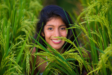 Naklejka premium young happy and beautiful latin woman smiling playful having fun posing sweet isolated on green rice field in Asia tourist trip and Summer holidays travel and tourism