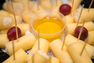 Cottage cheese rolls in cheese with honey on a plate.