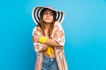 Young woman in bikini in summer holidays making doubts gesture while lifting the shoulders