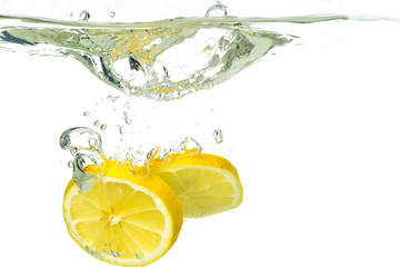 lemon slices and lime falling into water and splash on white background