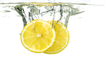 Fototapeta na wymiar lemon slices and lime falling into water and splash on white background
