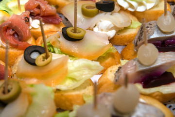 Sandwiches with herring and balyk on a plate.