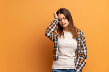 Young woman over brown wall with an expression of frustration and not understanding