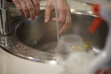man washing dishes in kitchen