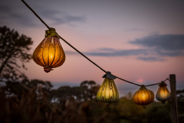 Paper lanterns against a sky at dusk.