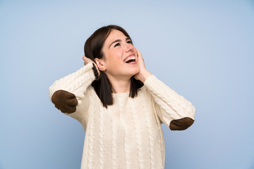 Young woman over isolated blue wall laughing