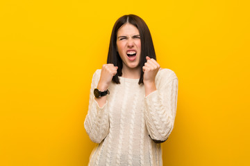 Young woman over isolated yellow wall frustrated by a bad situation