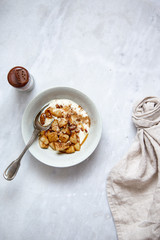 Baked apple with cinnamon and vegan coconut yogurt in rustic plate on marble background with copy space