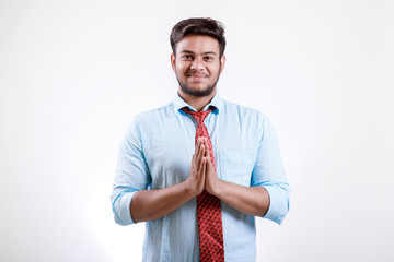 Handsome young Indian man standing isolated over white background