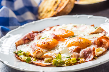 English breakfast fried bacon ham and eggson white plate