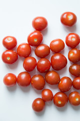 A handful of scattered tomatoes. Ripe cherry tomatoes on white background.
