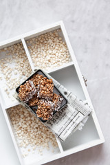 buckwheat crispbread or puffed buckwheat with chocolate  on wooden vintage textural box on marble background with copy space