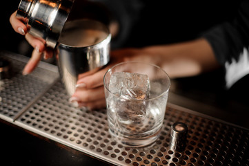 Close-up of shaker and glass with ice
