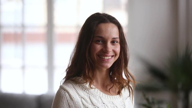 Video portrait of happy young woman posing at home