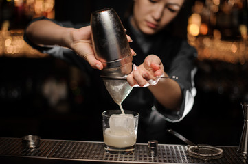Fototapeta na wymiar Close shot of bartender preparing cocktail adding sour mix in glass