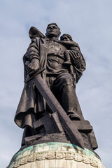 Fototapeta premium Bronze statue that symbolizes a Russian soldier who protects a child, destroying with a sword the nazi swastika, Treptower Park, Berlin