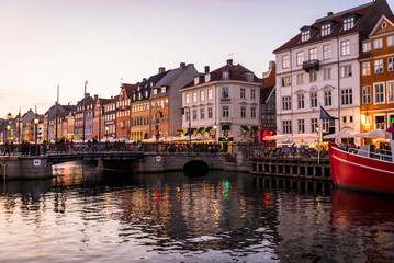 Nyhavn or New harbour is a 17th-century waterfront, canal and entertainment district lined by brightly coloured townhouses and bars, cafes and restaurants, Copenhagen, Denmark.