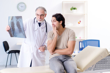 Fototapeta premium Young man visiting old male doctor radiologist 