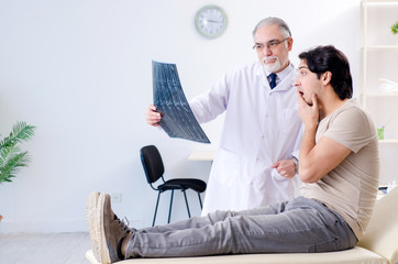 Young man visiting old male doctor radiologist 