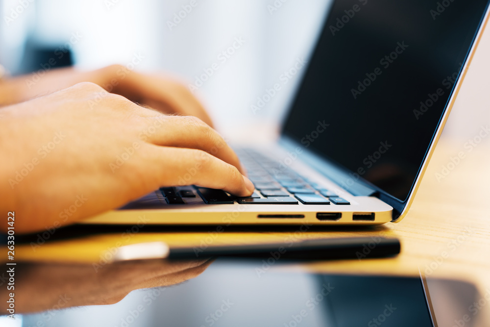 Poster sideview of man using devices on desktop