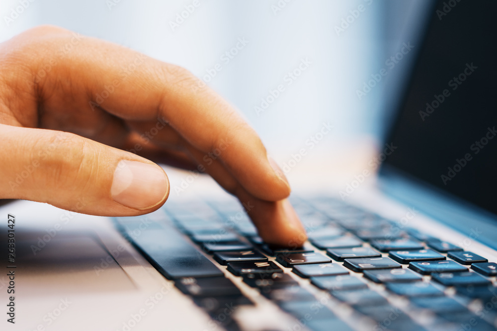 Poster sideview of businessman using laptop on workspace